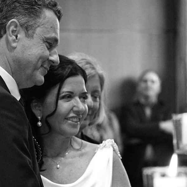 The couple looks devotedly at the flickering candles that add a romantic touch to the ceremony. The picture is in black and white.
