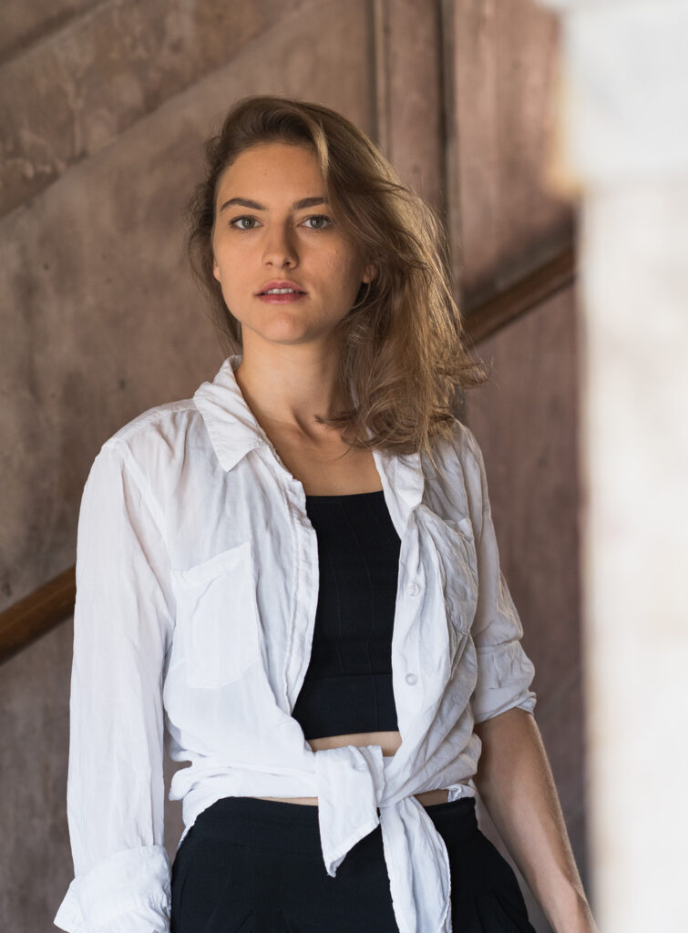 A young actress is standing on a staircase.