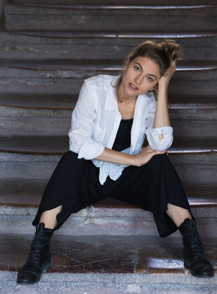 The young actress sits relaxed on the stairs.